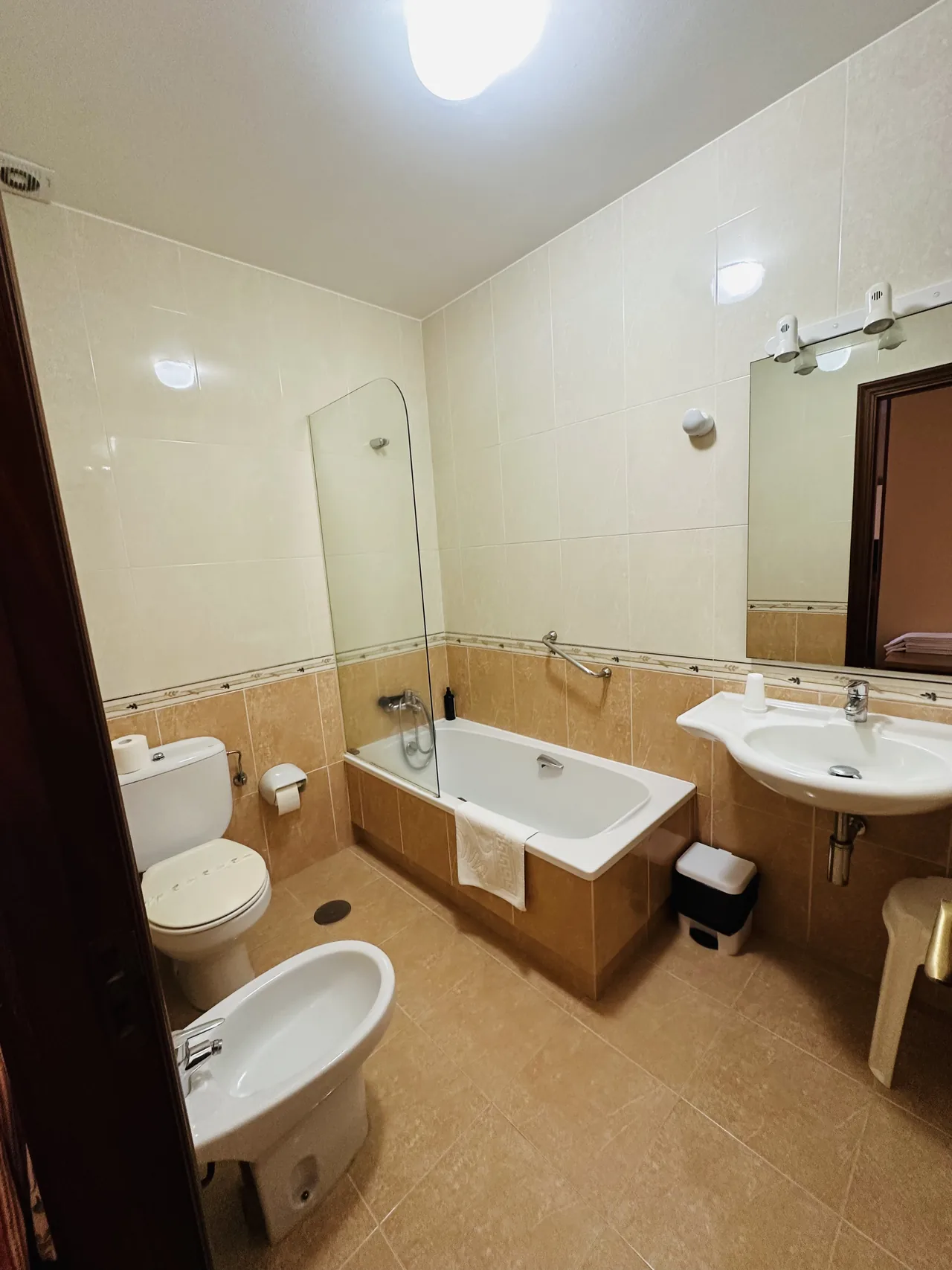 Otro baño del hotel con bañera, lavabo, espejo y sanitarios