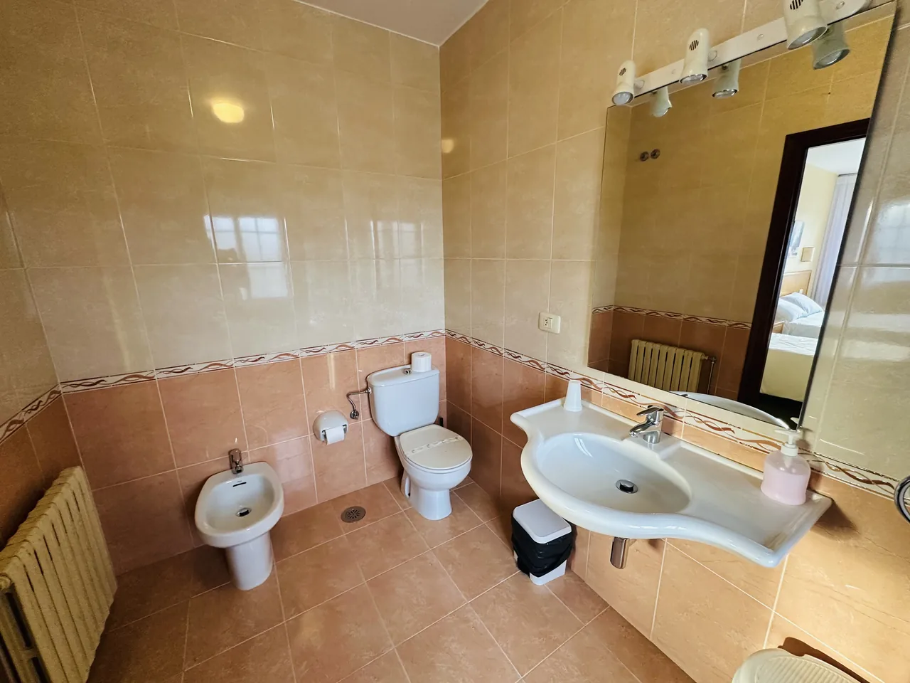 Baño del hotel con bañera, lavabo, inodoro y bidé