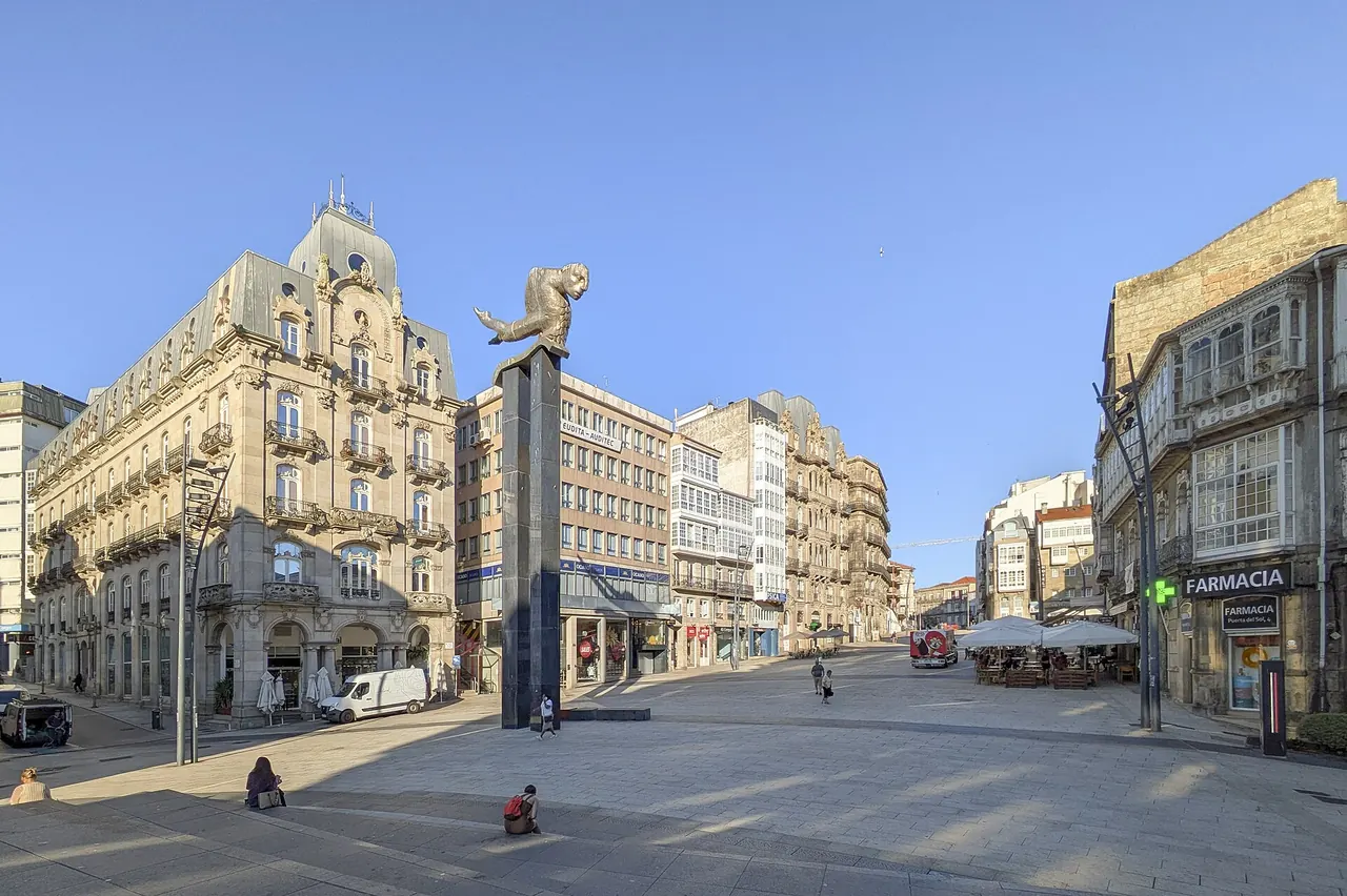 Porta do Sol, en Vigo: la escultura del Sireno sobre su columna, en una plaza amplia rodeada de edificios señoriales