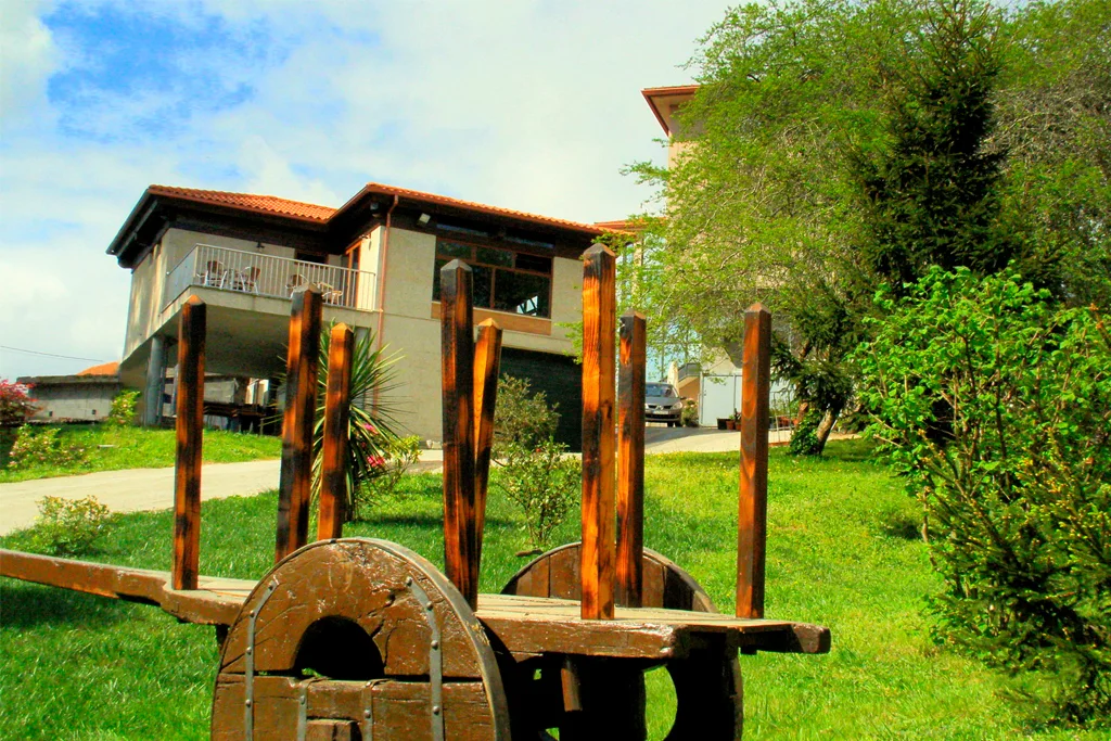 Jardín de El Bosque con zonas verdes y un carro de madera