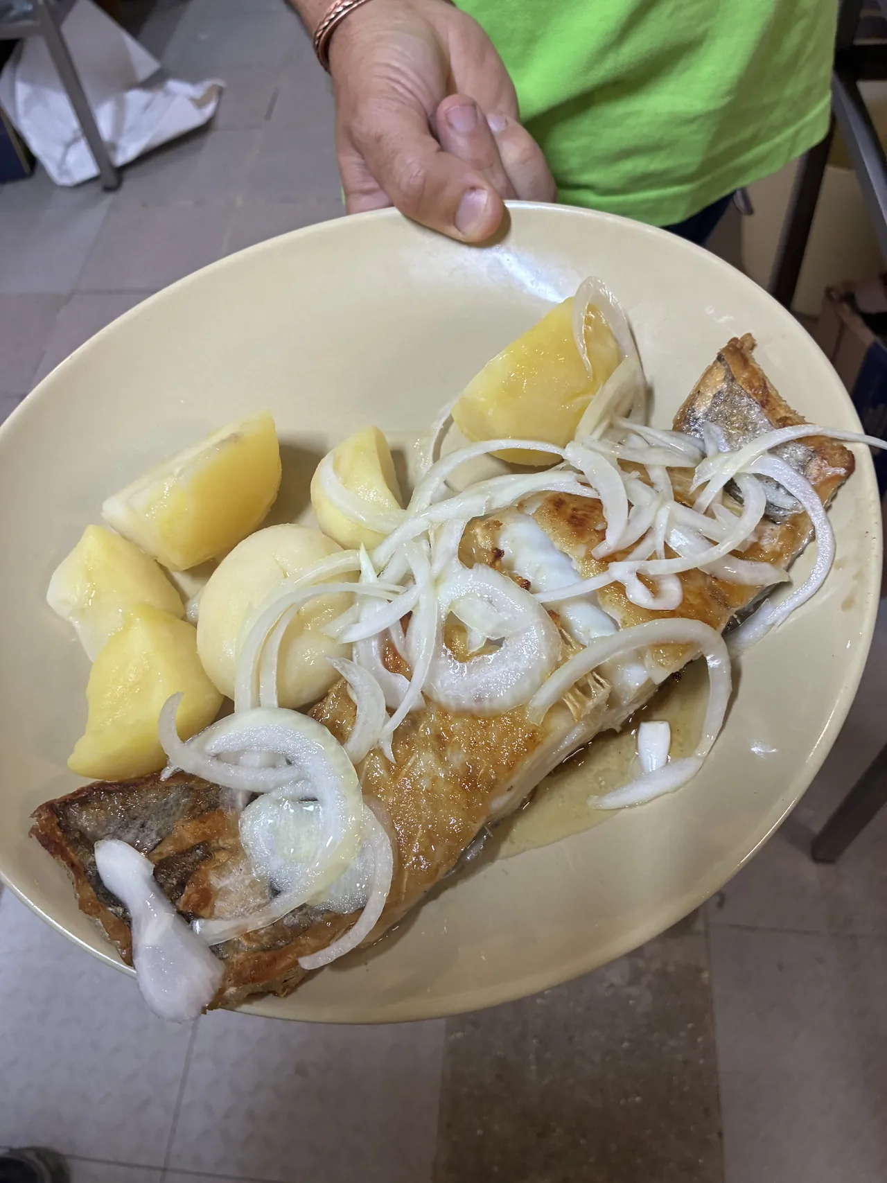 Pescado servido con cebolla, patatas y limón en El Bosque