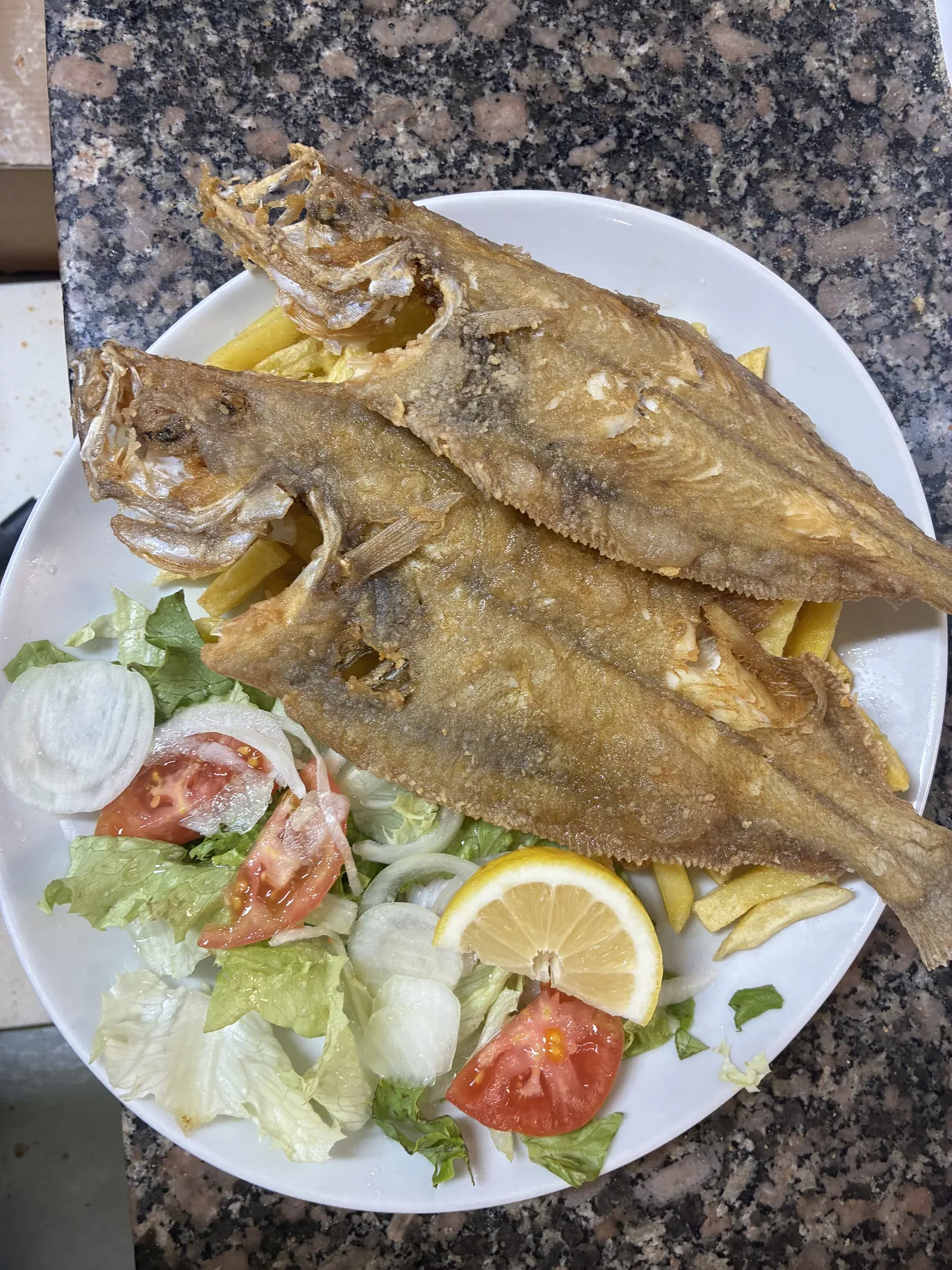 Pescados enteros con patatas, ensalada y limón en El Bosque