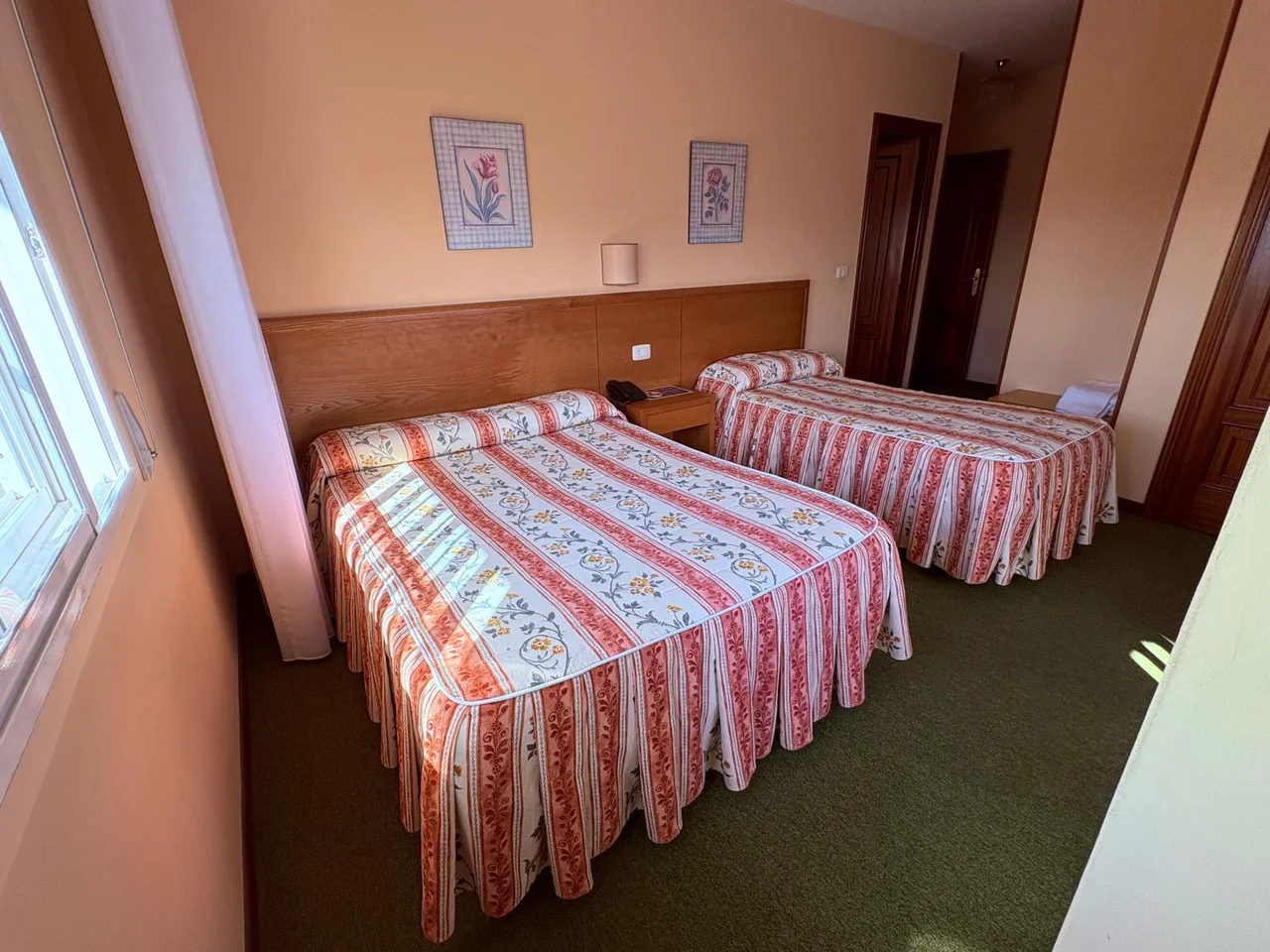 Dos camas separadas y un armario de madera en una habitación de El Bosque