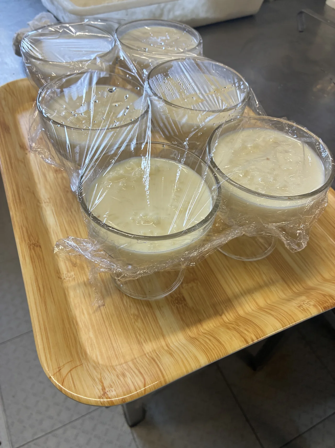 Vasos con un postre claro sobre una bandeja de madera