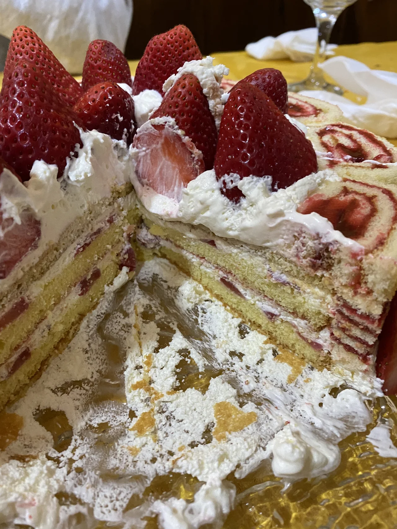 Porción cortada de una tarta de capas con fresas y nata