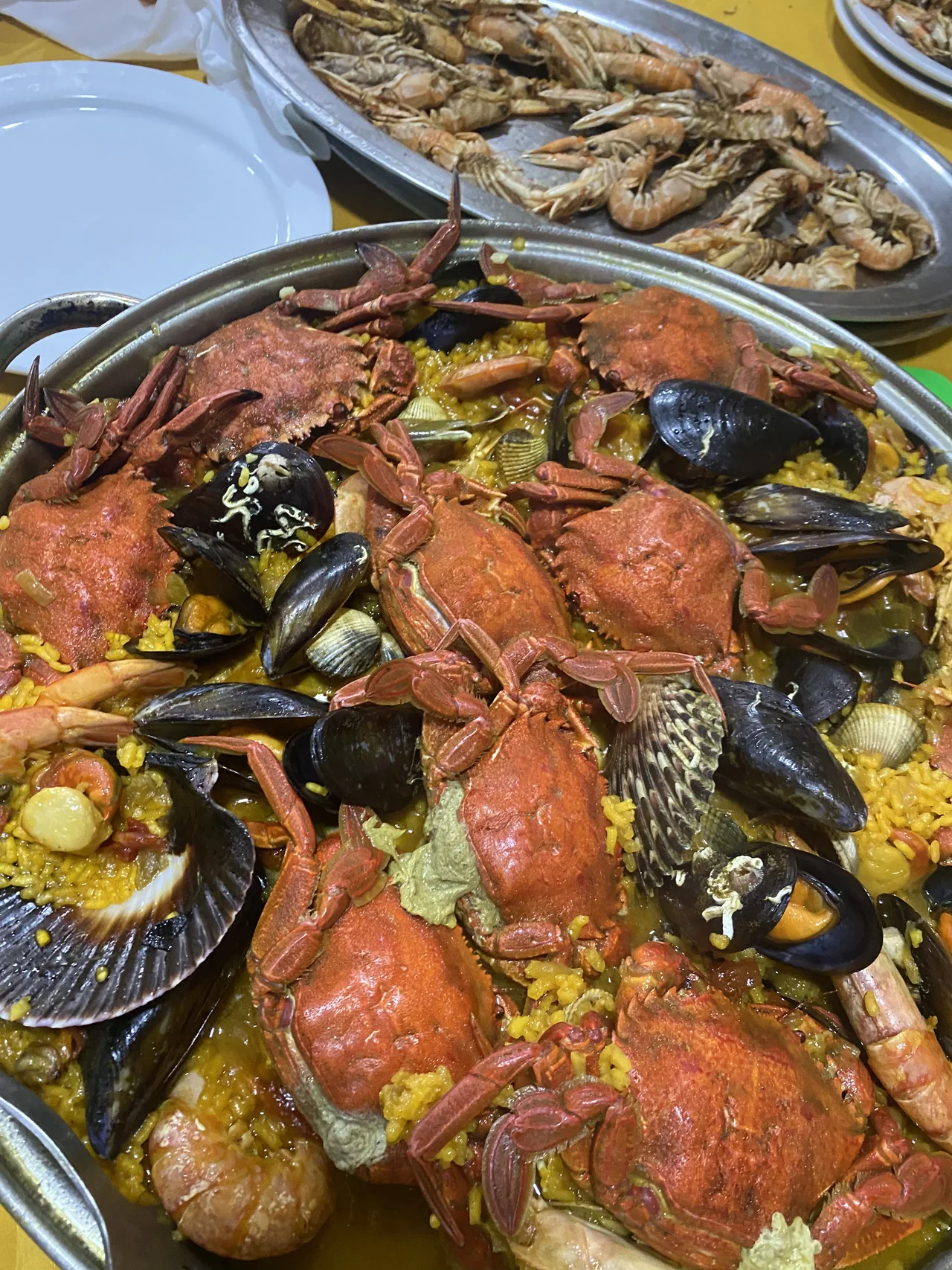 Paella con marisco sobre un mantel amarillo