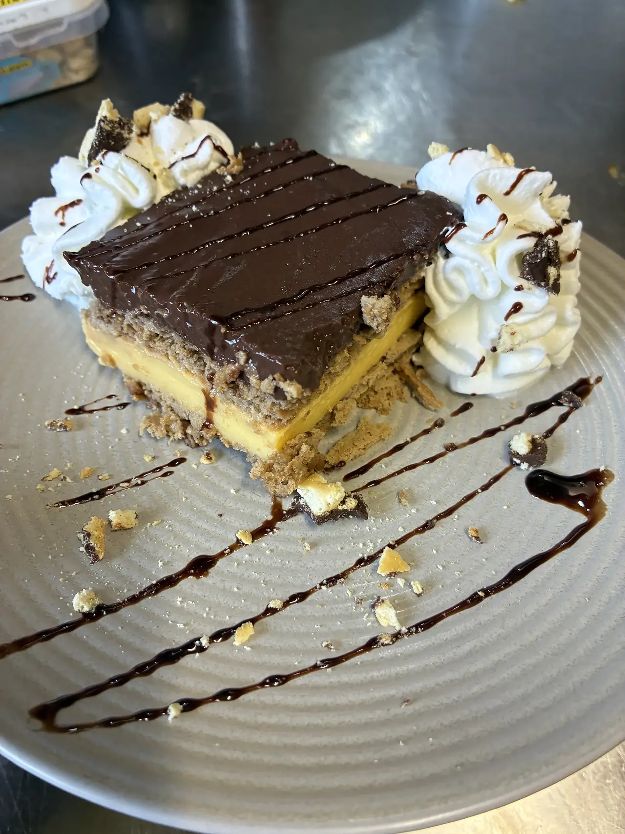 Porción de tarta de galleta, crema y chocolate con nata en El Bosque