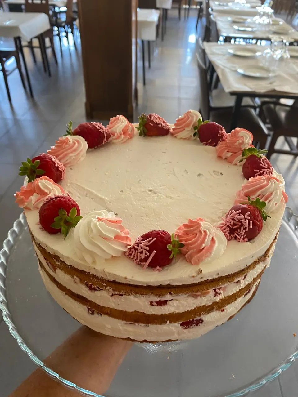 Tarta de bizcocho, nata y fresas decorada con rosetones, en el comedor de El Bosque (Mos)